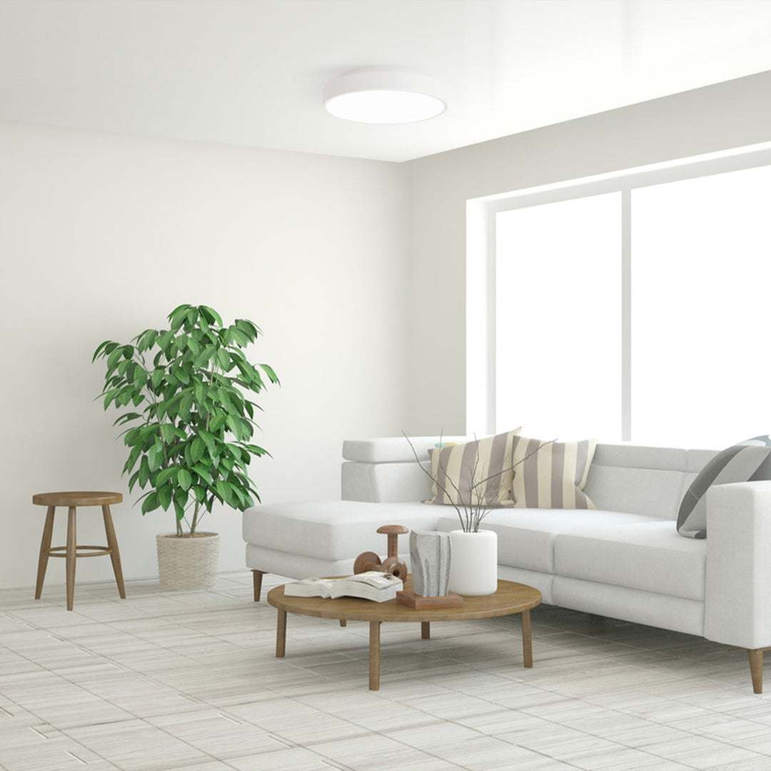 Modern LED ceiling light installed in minimalist living room with white walls and furniture