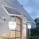 Elant Solar Golden Apple Light mounted on wall with solar panel illuminating outdoor space at dusk