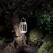 Handy solar rechargeable lantern hanging outdoors illuminating tree and garden at night