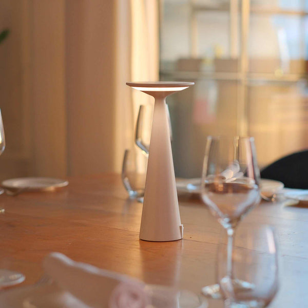Cordless Bama table lamp on wooden dining table, elegant modern design.