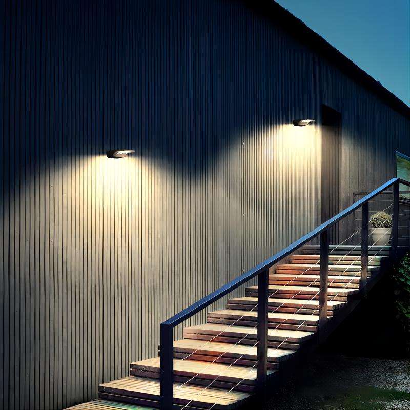 Two integrated solar lights mounted on a wall illuminating an outdoor staircase at night