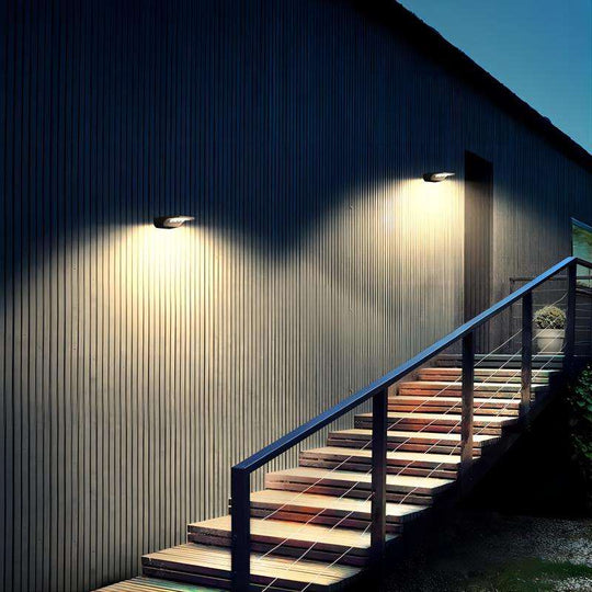 Two integrated solar lights mounted on a wall illuminating an outdoor staircase at night