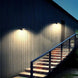 Two integrated solar lights mounted on a wall illuminating an outdoor staircase at night