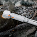 Compact white ECP002 multifunctional camping light with orange accents placed on rocks for outdoor use