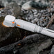 Compact white ECP002 multifunctional camping light with orange accents placed on rocks for outdoor use