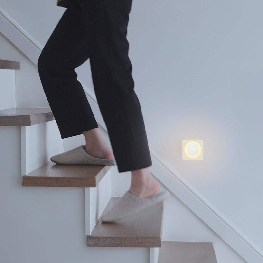 Yeelight Plug-In-Light sensor nightlight glowing softly on wall near stairs in dim lighting