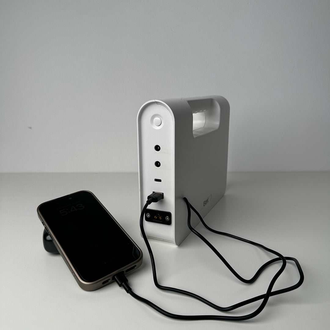 Solar rechargeable emergency lantern with power storage and USB connections, charging a phone.