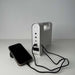 Solar rechargeable emergency lantern with power storage and USB connections, charging a phone.