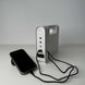 Solar rechargeable emergency lantern with power storage and USB connections, charging a phone.