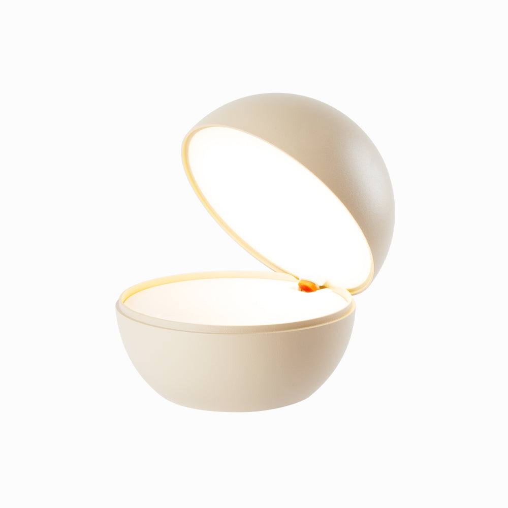Round cordless table lamp, innovative design, rechargeable LED, dimmable, 3000K warm light, cozy bedtime atmosphere.