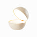 Round cordless table lamp, innovative design, rechargeable LED, dimmable, 3000K warm light, cozy bedtime atmosphere.