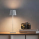 Plissé cordless table lamp on a desk, showcasing contemporary design and LED lighting.