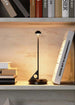 LUME Rechargeable Table Lamp with sleek, minimalist design on a shelf.