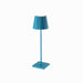 Plissé cordless table lamp with blue pleated shade and sleek design.