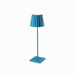 Plissé cordless table lamp with blue pleated shade and sleek design.
