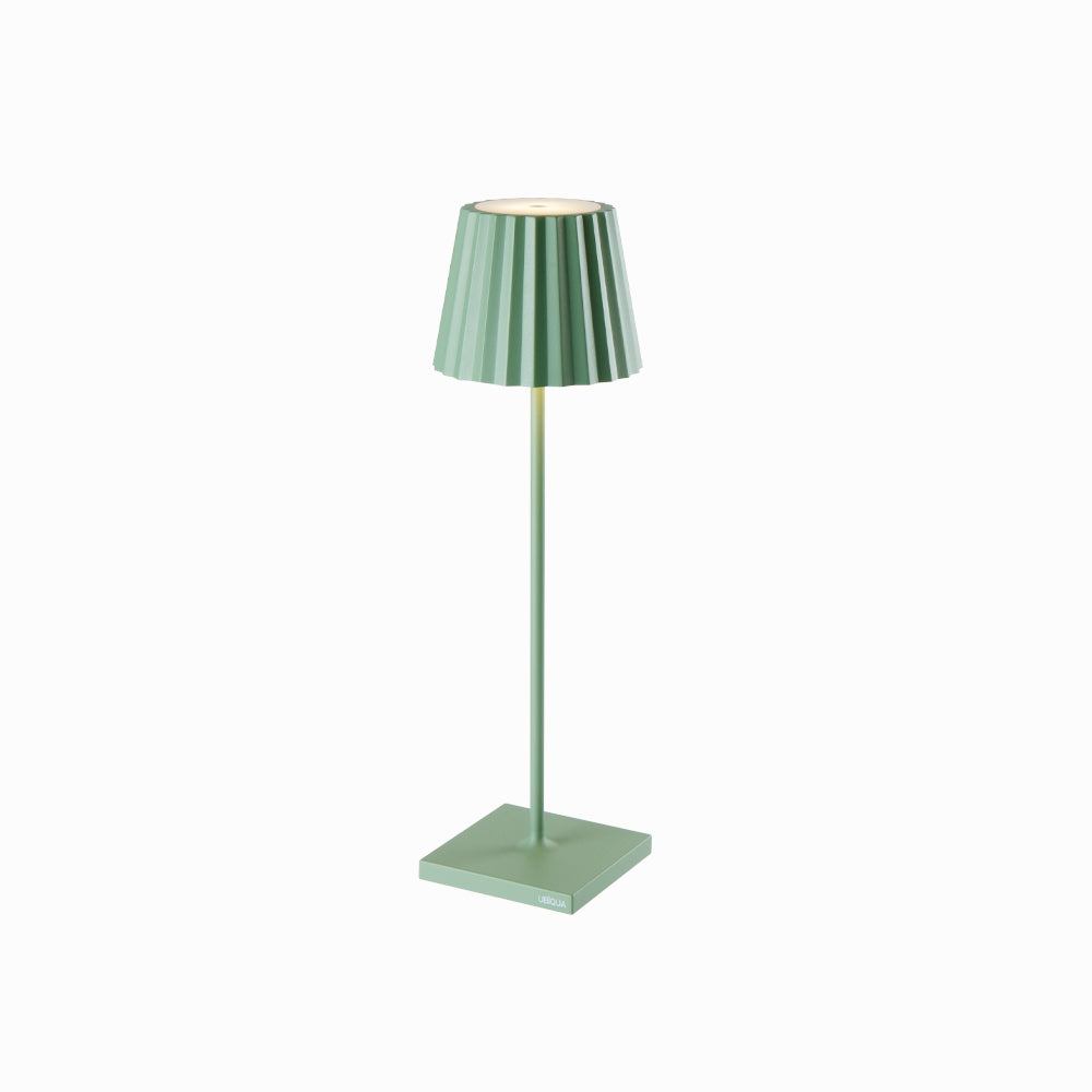 Green Plissé cordless table lamp with pleated shade standing on a square base.