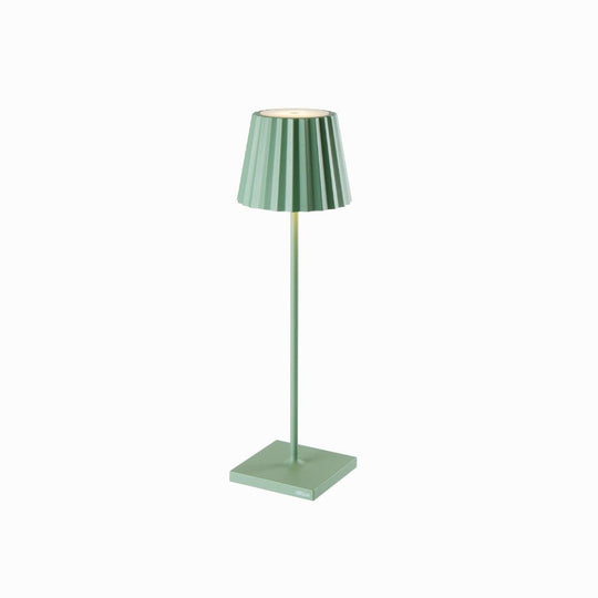 Green Plissé cordless table lamp with pleated shade standing on a square base.