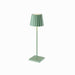 Green Plissé cordless table lamp with pleated shade standing on a square base.