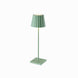 Green Plissé cordless table lamp with pleated shade standing on a square base.