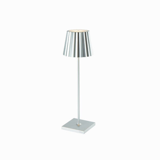 Plissé cordless table lamp with a sleek aluminum design and striped shade, ideal for versatile modern lighting.