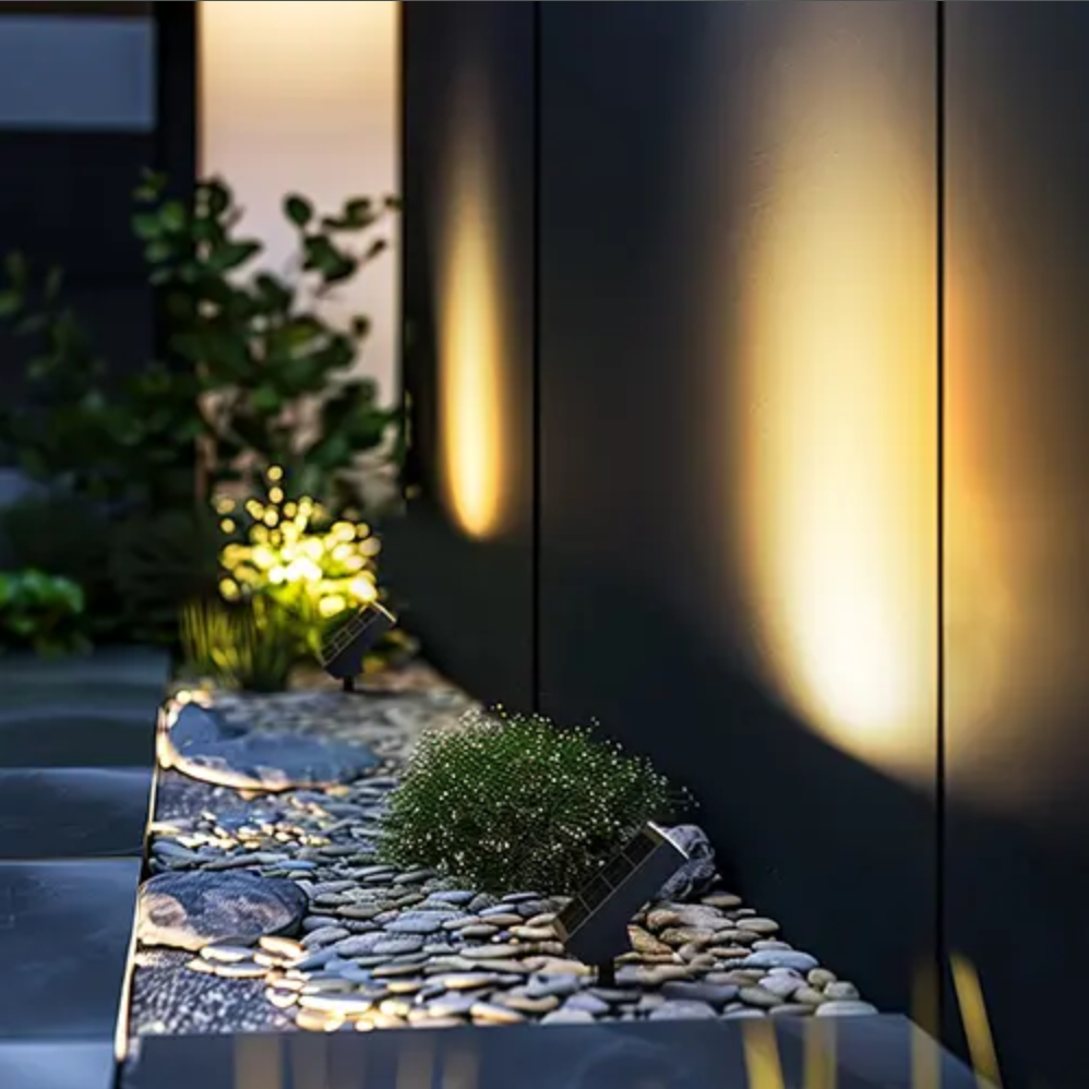 Solar path lights illuminating a garden walkway with stones and plants.