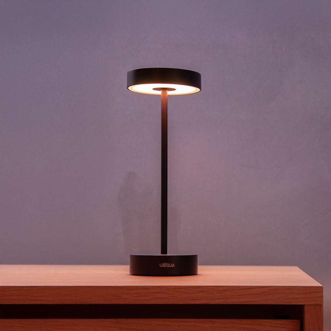 Standy Mini cordless LED table lamp with touch switch and adjustable dimming on wooden surface against purple wall