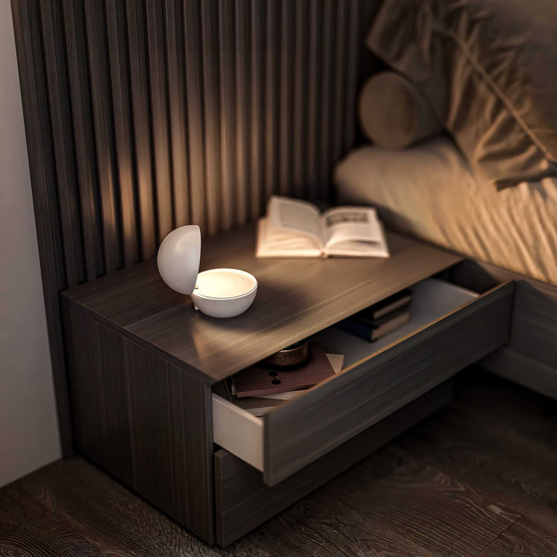 Cozy cordless table lamp with round design on a bedside table, creating a warm atmosphere.