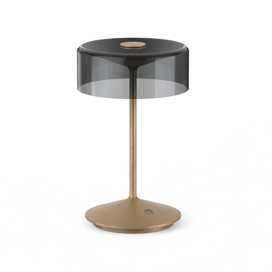 Cordless table lamp with smoky glass shade and gold base.
