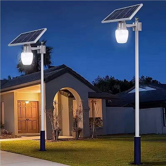Elant Solar Golden Apple Light pole-mounted with solar panel at night in front of a house