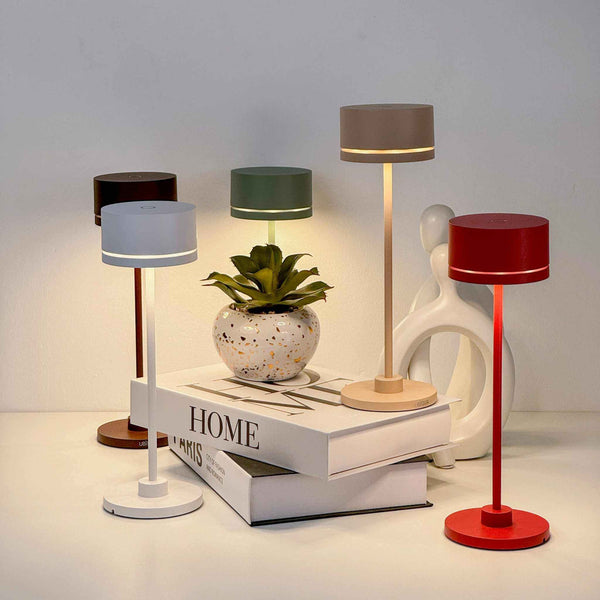 Duplo cordless table lamps arranged on a table showcasing various colors, featuring sleek designs and a modern decor setup.