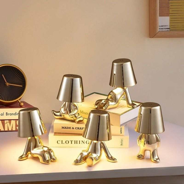 Little Golden Man Table Lamp with gold miniature Oscar statue design on a desk