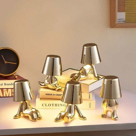 Little Golden Man Table Lamp resembling Oscar statues on a stylish tabletop.