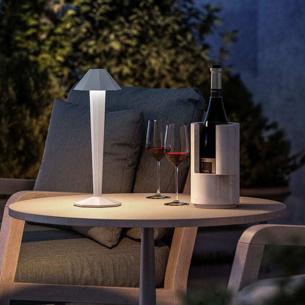 LED rechargeable table lamp on outdoor table with wine glasses and bottle in cozy setting