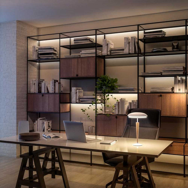 Modern LED rechargeable table lamp on office desk with bookshelf background